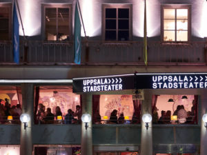 Uppsala stadsteaters fasad, människor i restaurangen utifrån