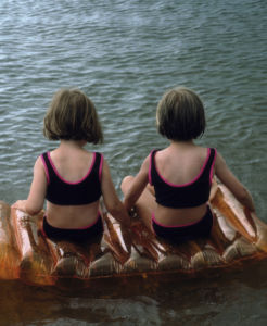 Två flickor på en badmadrass. Affischbild Idlaflickorna