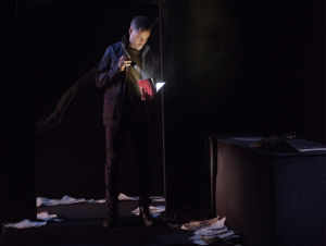 David Lenneman lyser i en bok med en ficklampa