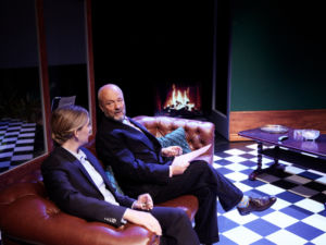 Skådespelarna Linda Kulle och Gustav Levin sittandes i en brun skinnsoffa. Eld sprakandes på en skärm i bakgrunden.