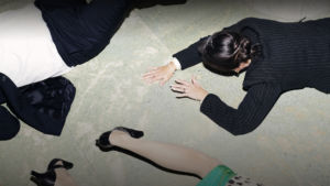 Tre överklass-klädda personer kryper på golvet