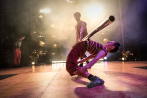 Cirkusartist balanserar ett rör på magen