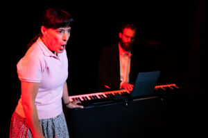 Åsa Forsblad Morisse sjunger i karaktär som Paula, Per Wickstöm bakom på piano, föreställningsfoto Sommar