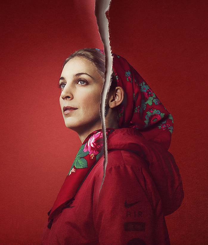 En kvinna i röd sjal tittar ut i fjärran. Ett riv går rakt genom bilden