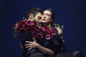 En man och en kvinna kramar varandra och håller i blommor