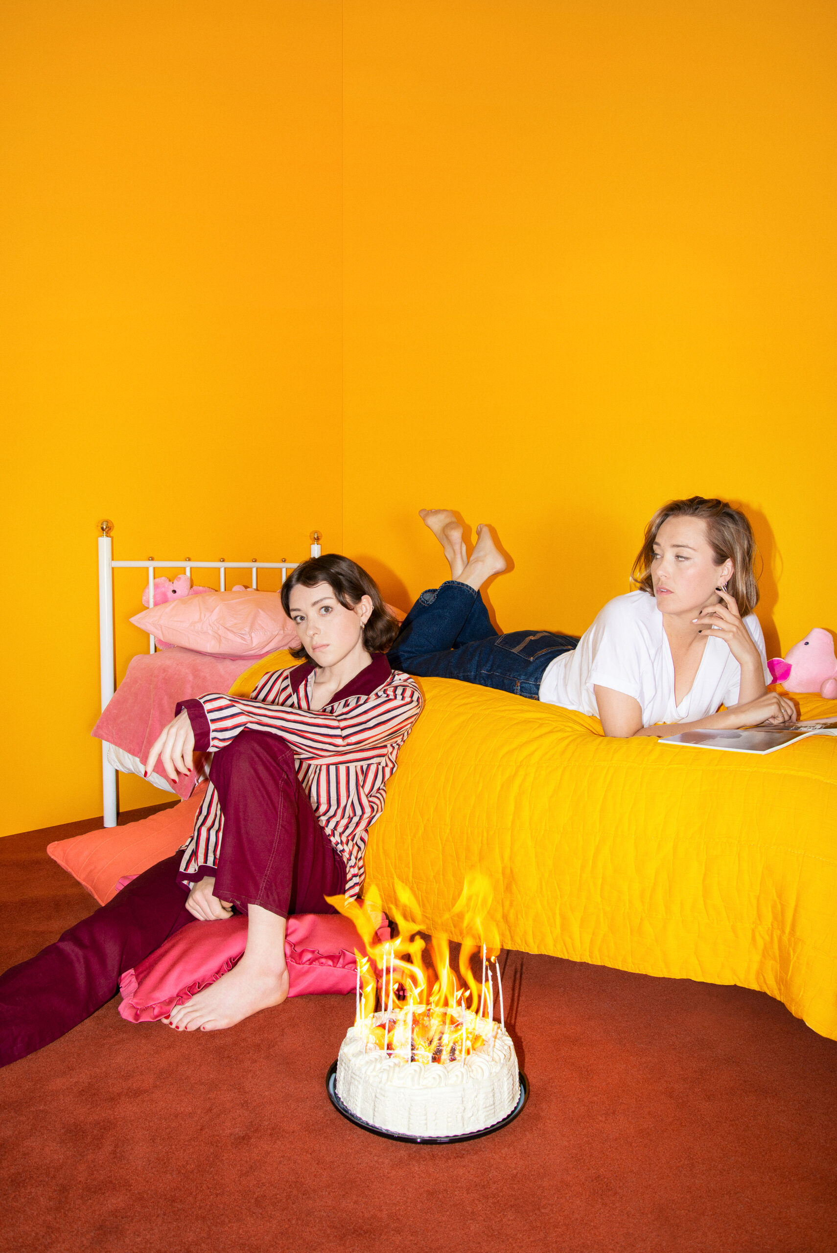 Tvp systrar i ett sovrum som går i orange, en brinnande tårta i förgrunden