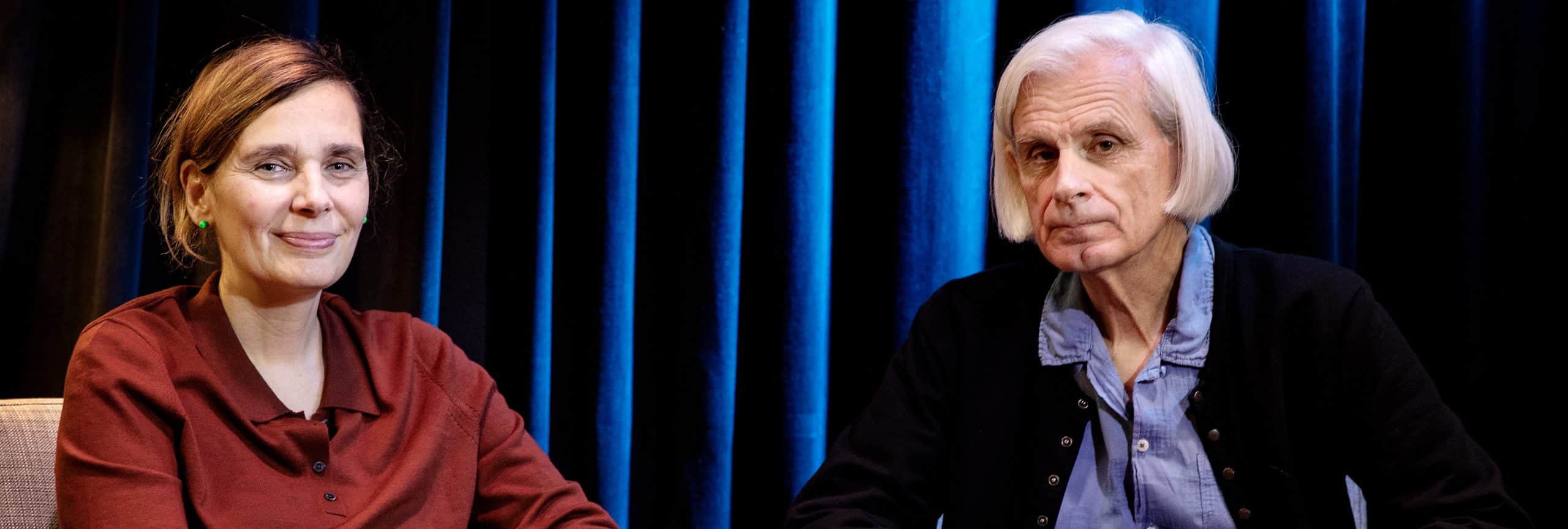 två personer, en kvinna och en man, sitter i varsin fotölj och tittar in i kameran.