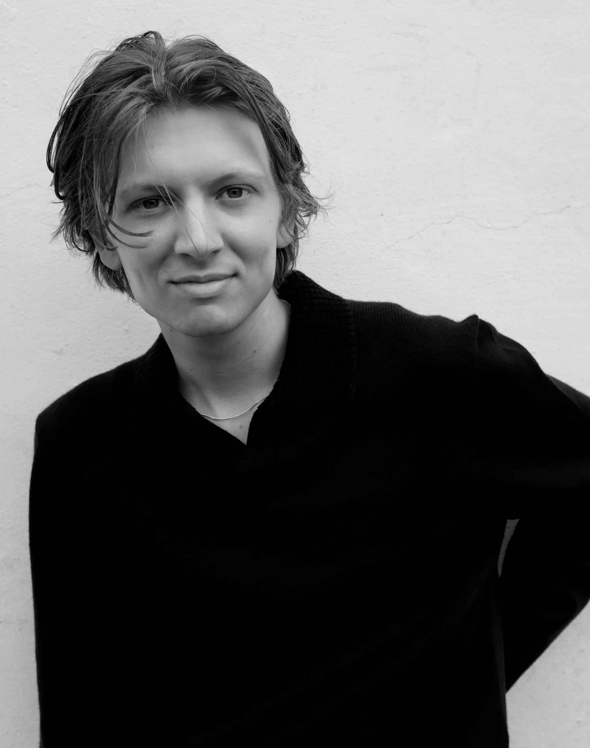 Porträtt, ung man med mellanlångt hår.