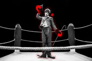 svartvit bild på en man som ser ut so Charlie Chaplin i en boxningsring. illustrationer i form av boxningshandskar är ritade på i rött